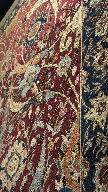 Close detail of a deep red carpet with floral patterns