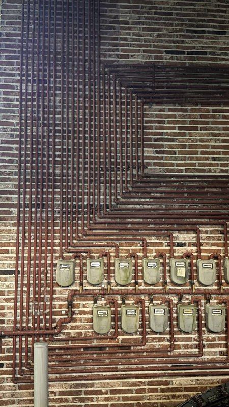 A wall of glass blocks and brick with utility meters