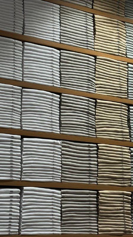 Neatly stacked rows of folded grey towels