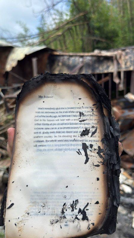 A burned book page, its edges charred black