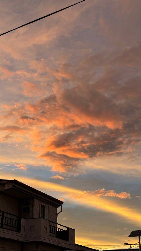 Fiery orange and pink clouds sweeping across the evening sky
