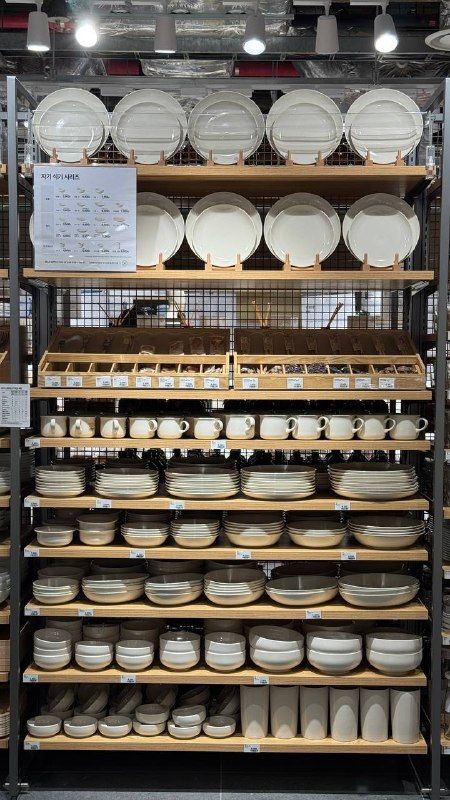 Shelves stacked with white bowls and plates in a homeware shop